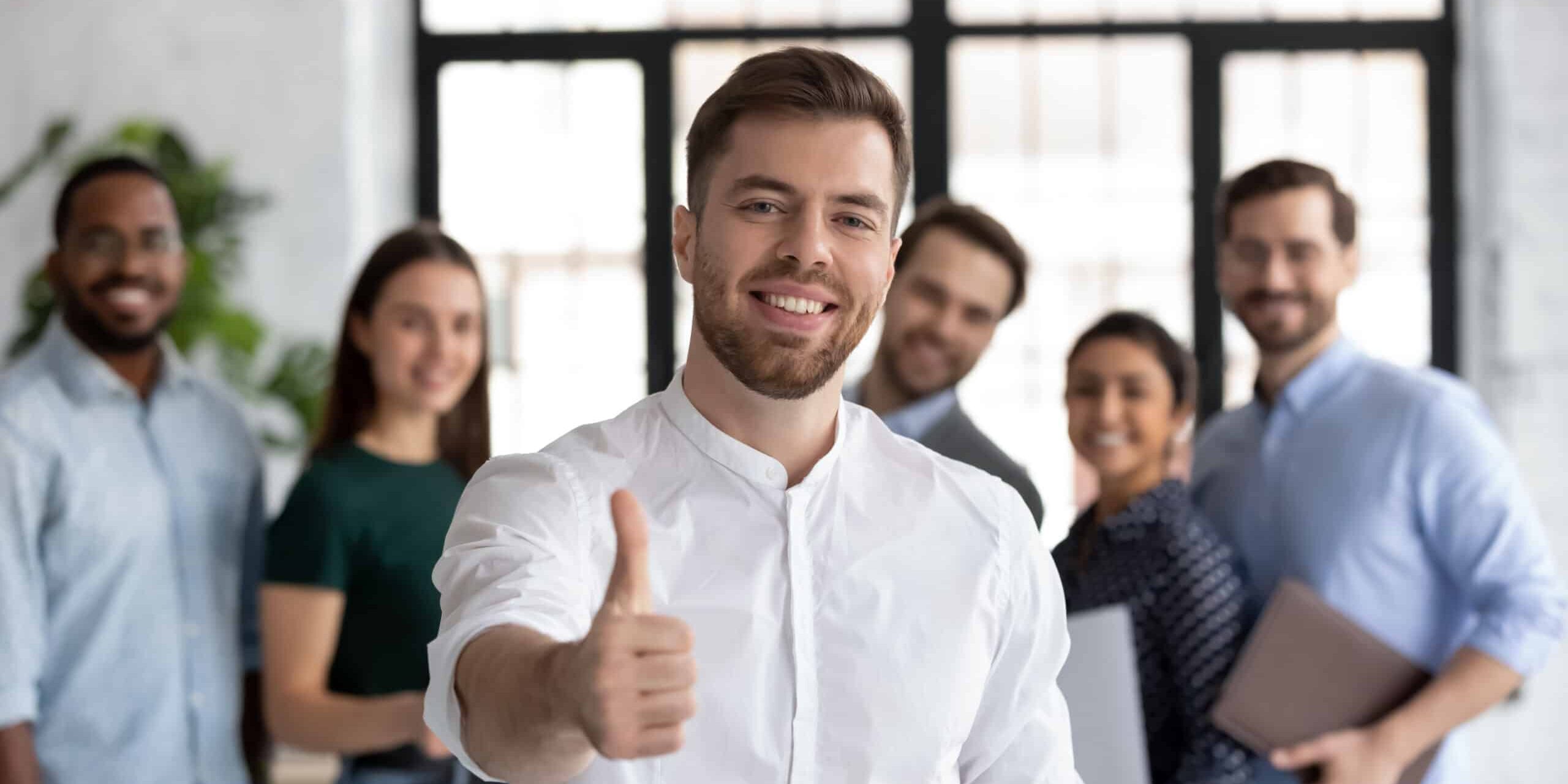 Happy employee satisfied with career and good job in great staff. Intern giving approval to corporate coach and training. Business leader proud of his team. Portrait of client making thumb up
